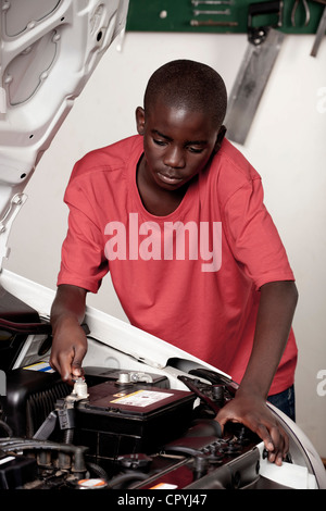 Afrikanischen Kindes arbeitet an einem Automotor Stockfoto