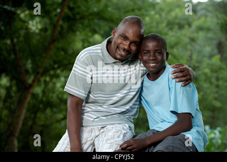 Afrikanischen Vater und Sohn sitzen draußen in einem Garten Stockfoto