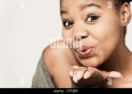 Nahaufnahme der junge schwarze Frau weht Kuss an der Kamera Stockfoto