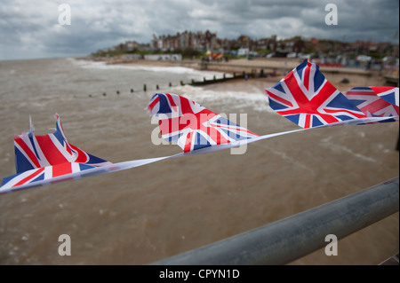 Southwold Strand und Union Jack-Flaggen gesehen von der Pier, Southwold, Suffolk, England, UK. 4. Juni 2012 Union Jack Fahnen flattern Stockfoto