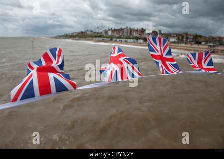 Southwold Strand und Union Jack-Flaggen gesehen von der Pier, Southwold, Suffolk, England, UK. 4. Juni 2012 Union Jack Fahnen flattern Stockfoto