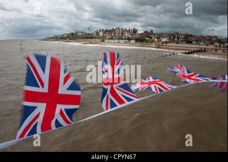 Southwold Strand und Union Jack-Flaggen gesehen von der Pier, Southwold, Suffolk, England, UK. 4. Juni 2012 Union Jack Fahnen flattern Stockfoto