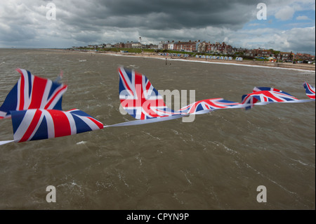 Southwold Strand und Union Jack-Flaggen gesehen von der Pier, Southwold, Suffolk, England, UK. 4. Juni 2012 Union Jack Fahnen flattern Stockfoto