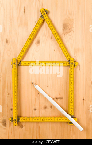 Faltung des Tischlers Herrscher in Form eines Hauses neben einem Bleistift gefaltet Stockfoto