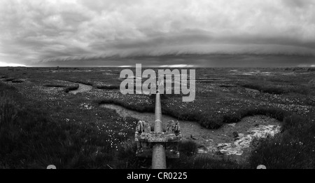 Stürmischen Wolken um den Rand des Sumpfes bei Toynbee an der North Norfolk Küste mit Pipeline Überschrift über das Moor Stockfoto