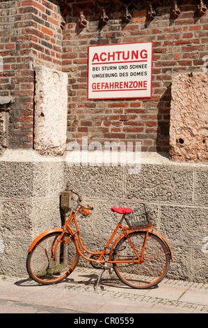 Orange Bike in der Gefahrenzone bei Sturm und Schnee auf der Wand, Frauenkirche oder Frauenkirche, München, Oberbayern Stockfoto
