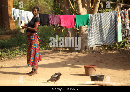 Eine Frau stellt Kleidung zum Trocknen auf die Linie im Dorf von Djorbana, Region Zanzan, Côte d ' Ivoire Stockfoto