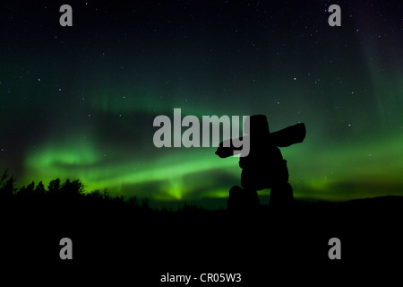 Silhouette der Inuit Steinmann, Inukshuk, Inuksuk, steinerne Wahrzeichen oder Cairn, Northern Lights, Polar Aurora oder Aurora Borealis Stockfoto