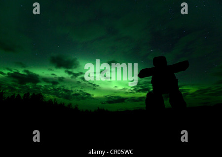 Silhouette der Inuit Steinmann, Inukshuk, Inuksuk, steinerne Wahrzeichen oder Cairn, Northern Lights, Polar Aurora oder Aurora Borealis Stockfoto