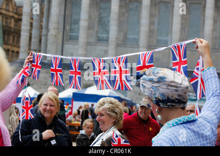 Zwei Straßenkünstler mit einer Reihe von Union Jack-Flaggen während der Queens Diamond Jubilee-Feierlichkeiten in Birmingham. Stockfoto