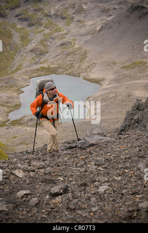 Wanderer gehen mit Stöcken in felsigen Hügeln Stockfoto