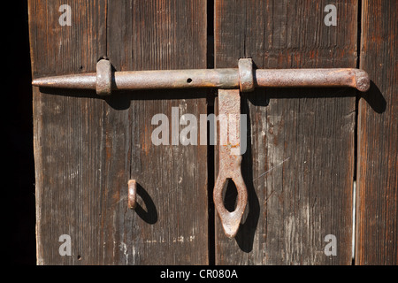 Alte rostige Grundnahrungsmittel auf einem hölzernen Schuppen. Stockfoto