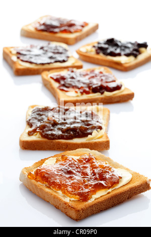 Sechs Scheiben Toast mit verschiedenen Marmeladen, Rhabarber Marmelade, Marillenmarmelade, Erdbeermarmelade, Orangenmarmelade Stockfoto