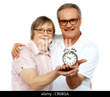 Im Alter von paar mit Wecker auf Palm isoliert auf weiß Stockfoto