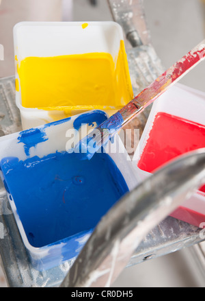 Wannen von Farbe auf der Stufe einer Leiter Stockfoto