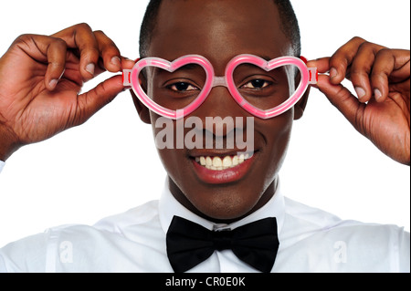 Lächelnder Mann mit Herz geformt Brillen. Liebe und lustige Konzept Stockfoto