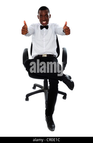 Afrikanische Männchen doppelt Daumen zur Kamera zeigt. Auf Stuhl sitzend Stockfoto