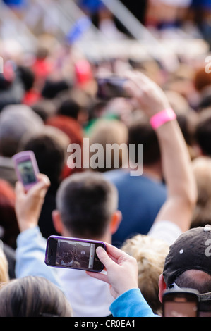 Viele Leute bei einem Konzert im freien Benutzung von Mobiltelefonen, Fotos oder Videos aufnehmen Stockfoto