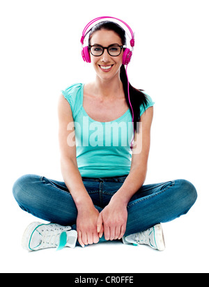 Teenager auf Boden sitzen und Musik hören. Alle auf weißem Hintergrund Stockfoto