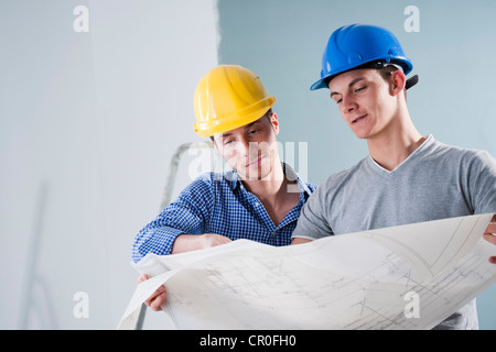 Zwei junge Handwerker betrachten einen Bauplan Stockfoto