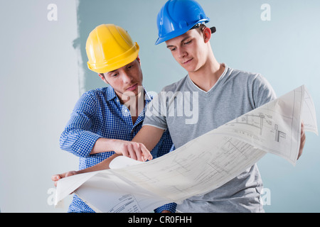 Zwei junge Handwerker betrachten einen Bauplan Stockfoto