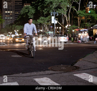 Ein Mann fährt Rad ohne Helm in der Nacht in New York City. Stockfoto