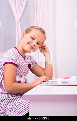 Junge Schülerin ihre Hausaufgaben an ihrem Schreibtisch Stockfoto