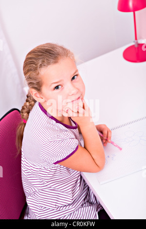 Junge Schülerin ihre Hausaufgaben an ihrem Schreibtisch Stockfoto