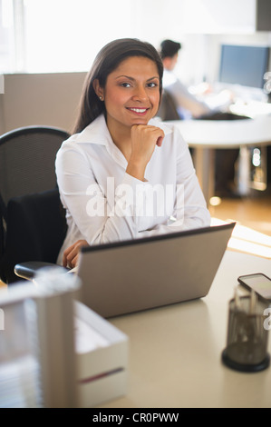 USA, New Jersey, Jersey City, Geschäftsfrau, die Arbeiten am Laptop, Geschäftsmann im Hintergrund Stockfoto