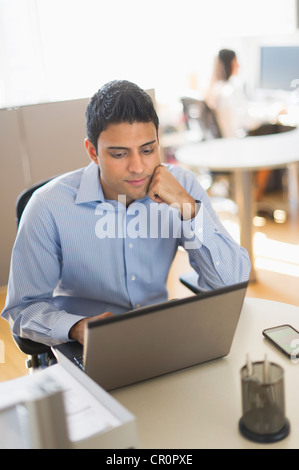 USA, New Jersey, Jersey City, Geschäftsmann arbeiten am Laptop, Geschäftsfrau im Hintergrund Stockfoto