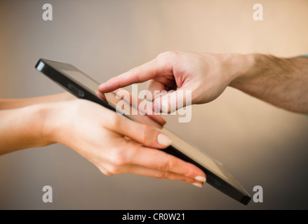 Nahaufnahme eines Mannes und Weibes Hände mit digital-Tablette, Studio gedreht Stockfoto