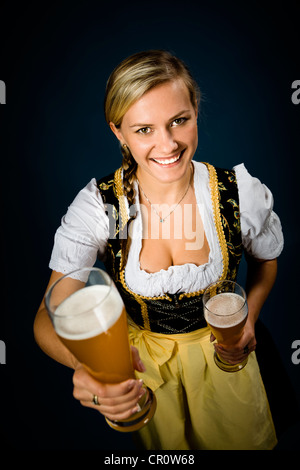 Bayerische Frau gekleidet in traditionellen Dirndl, hält Biergläser Stockfoto