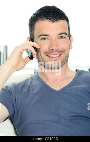 entspannter Mann mit einer Kommunikation mit einem cellephone Stockfoto