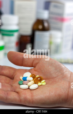Pillen in der Hand vor Apotheke Regal Hintergrund Stockfoto
