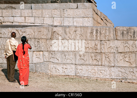 Indische Paare betrachten die Wandschnitzereien. Mahanavami Dibba. Königliche Gehege. Hampi. Indien Stockfoto