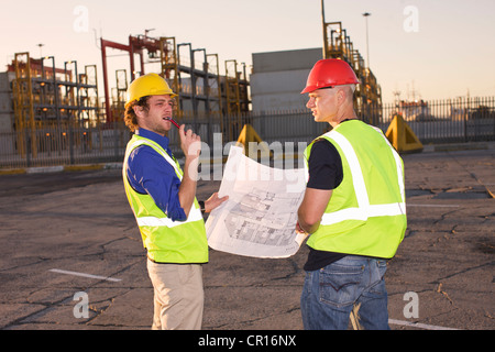 Bauarbeiter, die Blaupause zu lesen Stockfoto