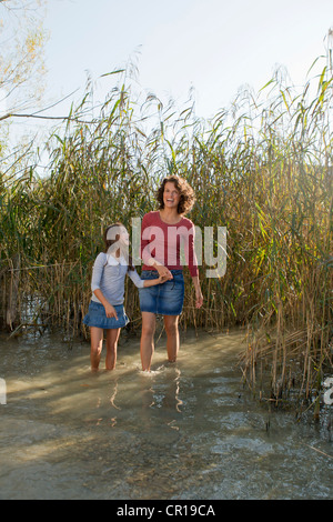 Mutter und Tochter gehen in Teich Stockfoto