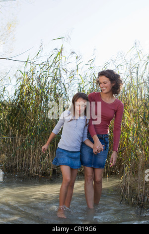 Mutter und Tochter gehen in Teich Stockfoto