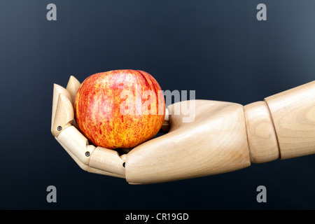 Stillleben Apfel in hölzernen Hand vor einem dunklen Hintergrund Stockfoto