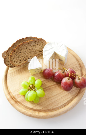 Blauschimmelkäse auf einem Brett mit Brot und Trauben Stockfoto