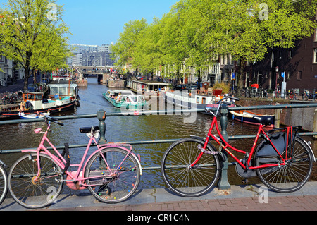 Niederlande, Amsterdam, Fahrräder und Lastkahn auf einem Kanal Stockfoto