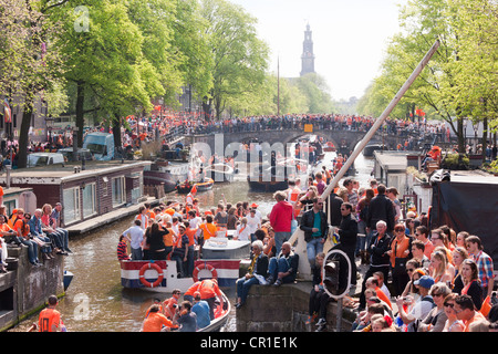 Königstag König Könige Tag Geburtstag in Amsterdam. Kanal-Parade in der Prinsengracht. Menschen tragen Orange, Boote feiern. Stockfoto