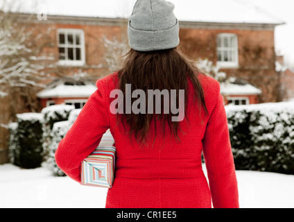 Frau mit Geschenk in Schnee gehüllt Stockfoto