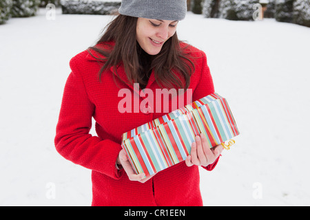 Frau mit Geschenk in Schnee gehüllt Stockfoto