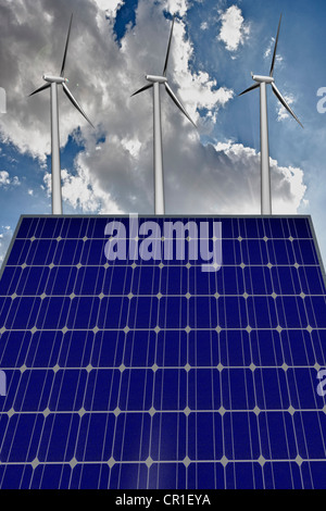 Windkraftanlagen und ein Solar-Panel vor blauem Himmel mit Wolken Stockfoto