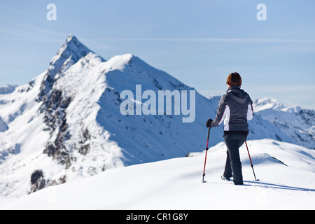 Wanderer im Schnee auf dem Gipfel Roethenspitz Berges oberhalb Penser Joch Pass, mit Blick auf den Gipfel des Penser Weißenhorn Stockfoto