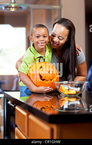 Mutter und Sohn Jack-o-Lantern schnitzen Stockfoto