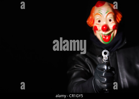 Mann in Clown Maske zeigenden Waffe Stockfoto