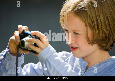 Mädchen, acht Jahre, Fotografieren mit einer digitalen Kamera Stockfoto