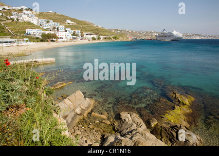 Griechenland, Kykladen, Insel Mykonos, Agios Stefanos, Strand und Kreuzfahrt Boot im Hintergrund Stockfoto